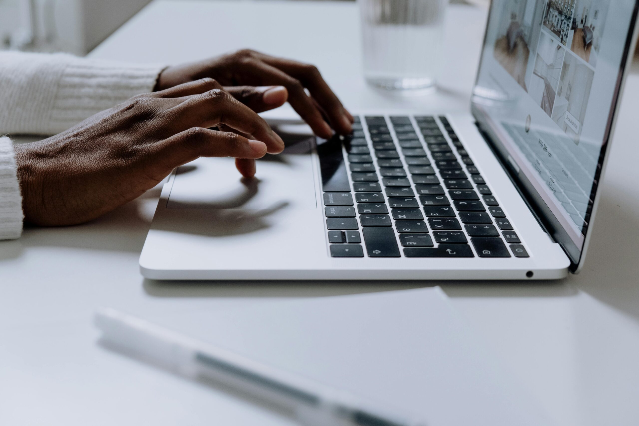 Hands typing on a sleek laptop keyboard; modern technology in use.