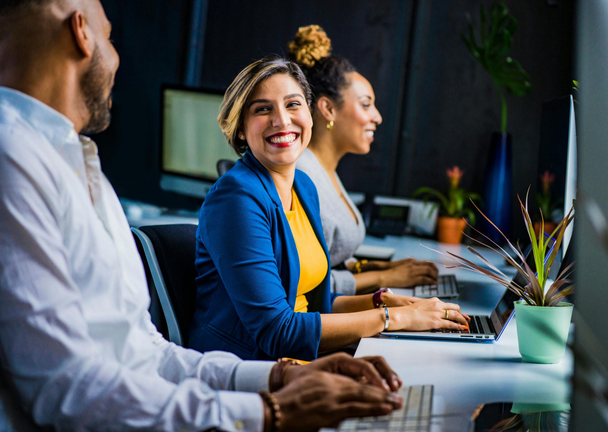 Stressed person with hands on head, looking overwhelmed in a modern office environment.